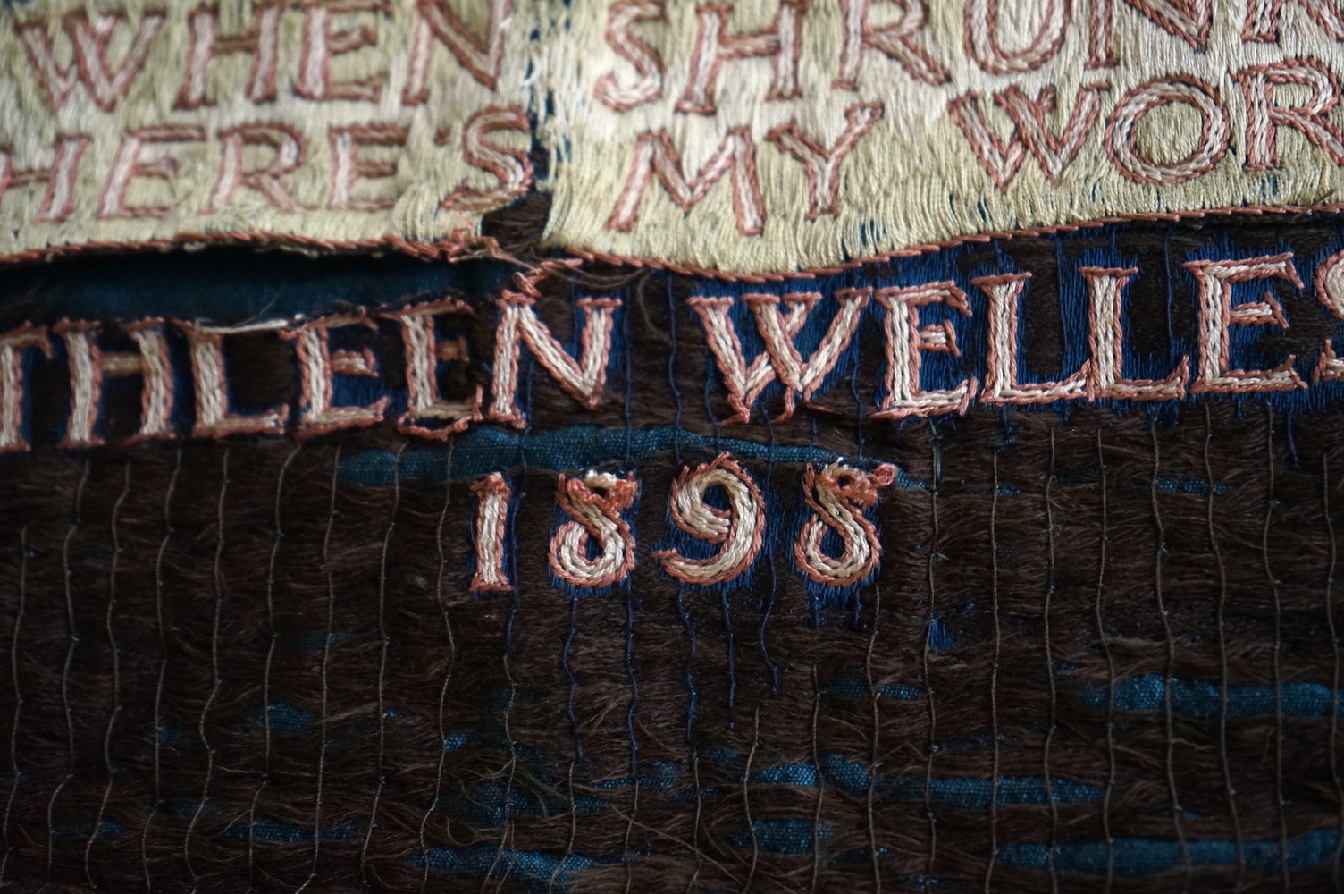 A large Arts and Crafts silk embroidered wall hanging, embroidered in the manner of May Morris with a large central scrolling flowering rose tree and banner embroidered with Salve and a two row motto below;, Rose leaves